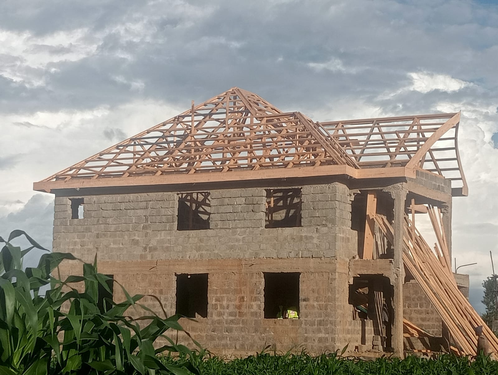 Roof truss structure on two-storey building under construction — ready for mabati